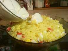 добавляем майонез в салат Нежность с крабовыми полочками и консервированной кукурузой