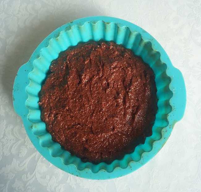 Смажьте силиконовую форму для выпечки растительным маслом. Выложите шоколадную массу в форму, разровняйте ложкой.