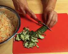 Огурцы свежие промываем водой, режим сначала на пласты 0,5 см, затем пласты разрезаем вдоль пополам, а лишь затем шинкуем на мелкие ломтики